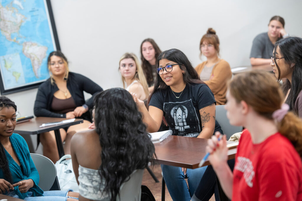 Student talks to professor during group discussion in class