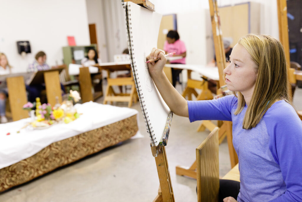 Two students participate in theatre class assignment with skit on stage with microphone