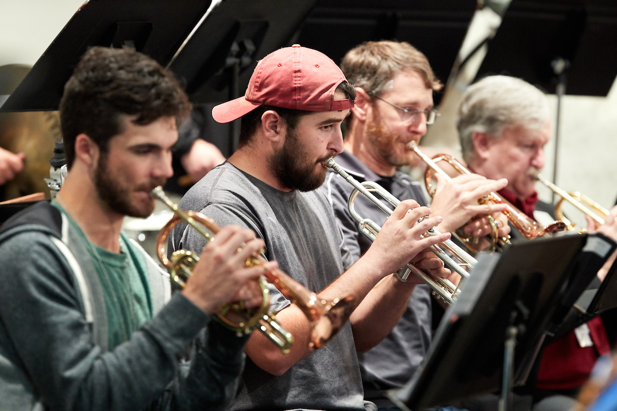 Group of music students perform on trumpets during music rehearsal