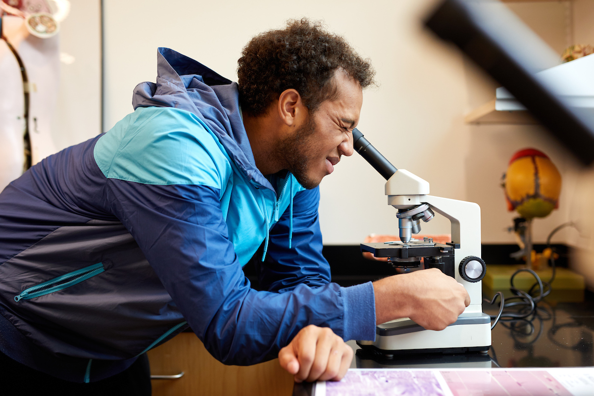Student looks into a microscope